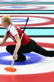 Jugadora de curling lanzando la piedra