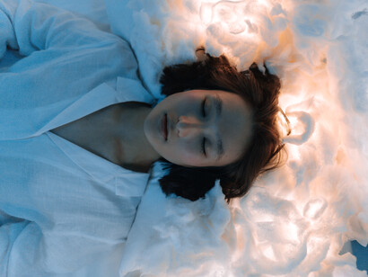 A woman asleep and dreaming with her head in the clouds