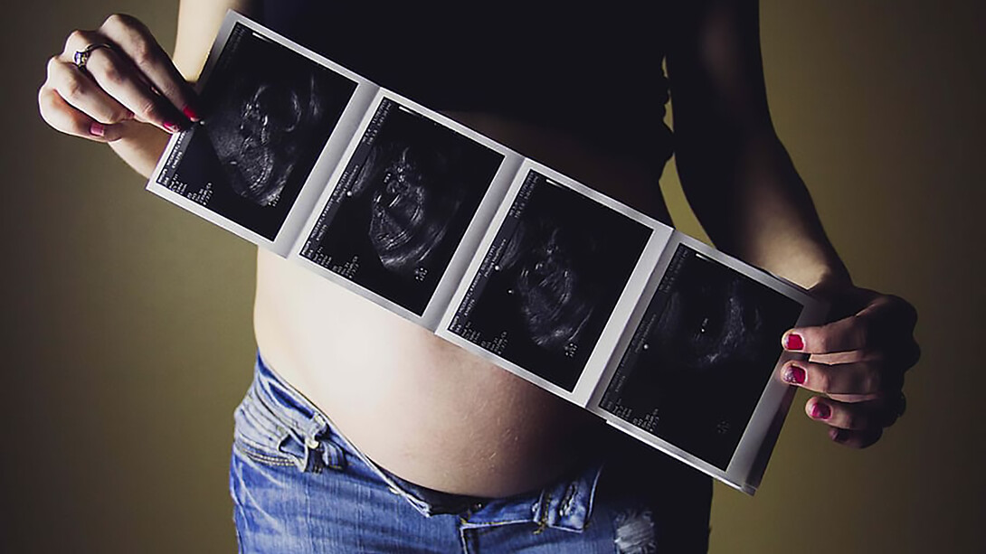 A teenage mother holding her ultrasound results, with a photo of her baby bump, reflecting the challenges of teenage pregnancy