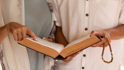 Front view of people from Christian and Muslim faiths praying together in unity