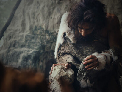 At the dawn of civilization, a caveman draped in animal hide wields a sharp stone hand axe, a primitive yet ingenious tool that forever changed the way humans hunted and survived