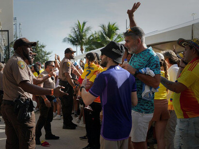 A checkpoint control tries to stop the unruly crowd