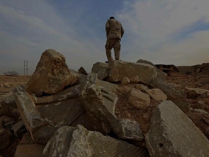 An Iraqi soldier stands on November 15, 2016, on the ruins of the archaeological site of Nimrud, which were severely damaged by ISIS