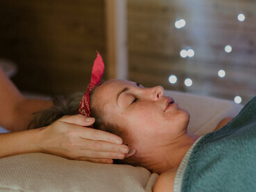 A relaxed woman experiences the soothing flow of reiki healing during an alternative massage session