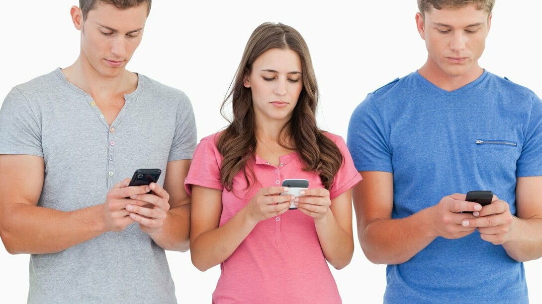 Jóvenes consultando las redes sociales desde sus móviles
