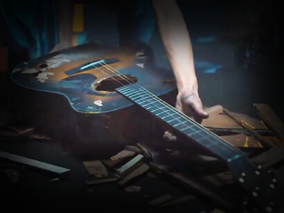 Captura de pantalla de "Uncrush" en el que se levanta una guitarra muy similar a la que aparece en la publicidad de Apple