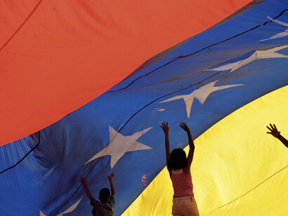 Two young Venezuelans hold up their flag