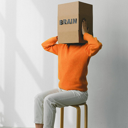 Pessoa com uma caixa na cabeça escrito "brain". Cultivar uma mentalidade positiva não é tarefa fácil