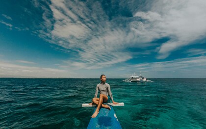 A woman wearing a rash guard in the sea in the Philippines, enjoying a peaceful travel moment