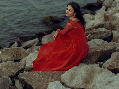 A young woman in a red dress, by a lake