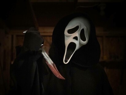 Ghost face from the Scream franchise films holding a bloody knife