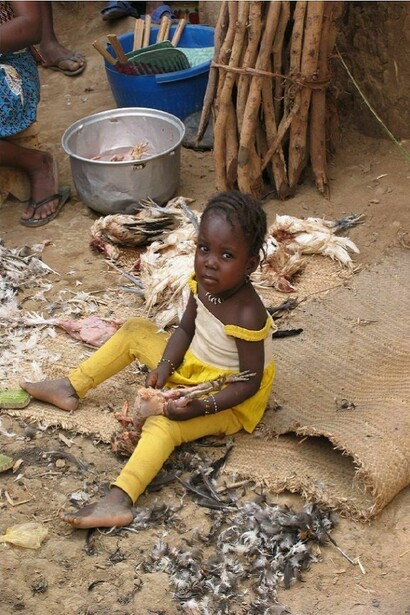 Bimba che spenna un pollo. Foto di Giovanni Sacchetti
