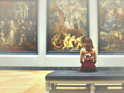 Ragazza osserva un quadro al museo. Mi siedo su una panca e resto a guardare