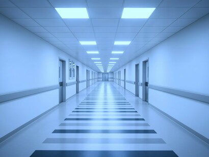 Empty hospital hallways evoke the inefficiency and waiting times described by patients forced to stand for hours without proper attention