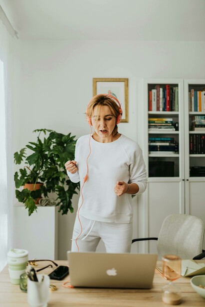 At home, a woman trains with headphones on, turning her workout into a dual session of fitness and language learning