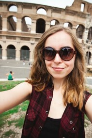 Una turista tomándose una autofoto delante del Coliseo en Roma