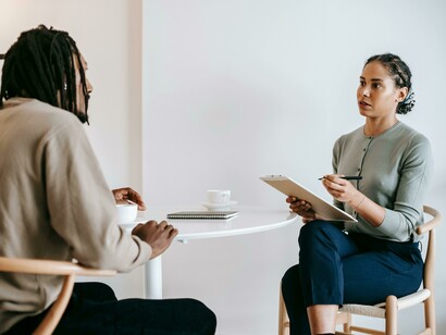 A psychologist taking notes while speaking with a patient