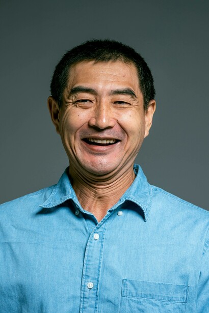 Primo piano di uomo che sta sorridendo ampiamente esprimendo una grande gioia