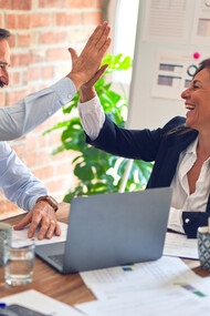 Two business executives high-five in support of one another