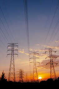 Electricity pylons standing tall against the evening sky, representing the strategic importance of grid resilience and capacity