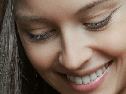 Woman with white teeth lowers her gaze