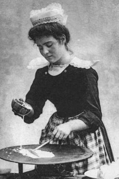 Les crêpes. Une crêpière dans le Finistère qui étale sa pâte sur un « bilig », une plaque épaisse en fonte