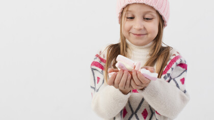 Menina com doces. O que importa são as mãos pequenas segurando com firmeza uma bandejinha de plástico