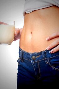 A woman with stomach problems drinking probiotic shots