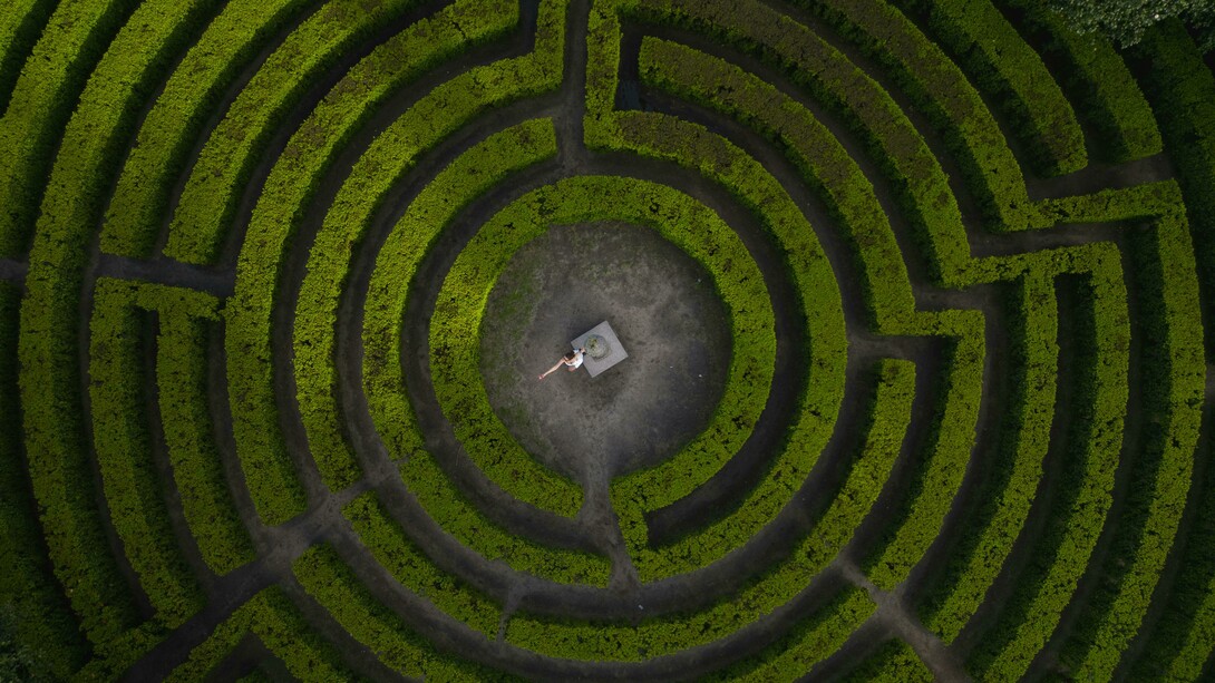 Porto, Portugal, a woman stands in the center of a labyrinth, framed by twisting paths and quiet symbolism