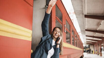 Empowered woman standing at train entrance, waving, symbolizing commitment to progress and positive change