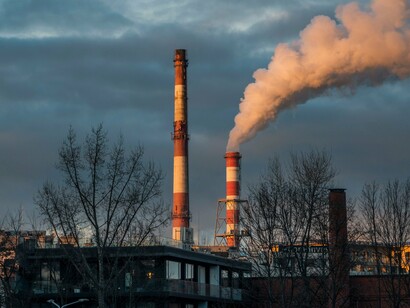 Factory chimneys filling the sky with pollution, symbolizing the environmental cost of fossil fuel dependence