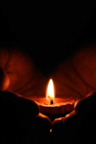 Mani con candela che illumina il buio