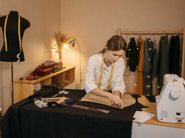 Mulher dedica-se à confecção de roupas em ambiente de trabalho especializado. Valorizar peças bem produzidas contribui para um consumo mais duradouro e responsável