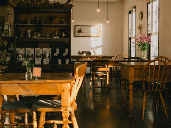 A warm, vintage café interior bathed in natural light, representing the charm and elegance of Japan's traditional kissaten culture