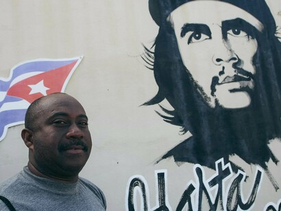 Homem em frente à pixação com rosto de Che Guevara. Frequentemente ocorre o engajamento com questões sociais, políticas e culturais, tornando os signos carregados cada vez mais de significados contextuais