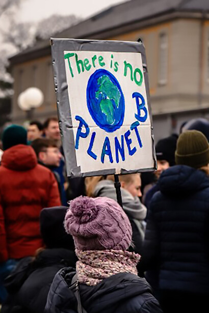 Crowd of activists protesting climate crisis and environmental issues in front of an urban building