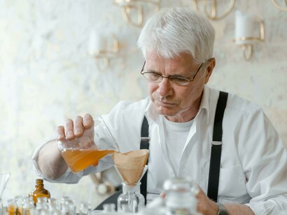 A perfumer smells a fragrance from a test tube, capturing a moment in the creation process