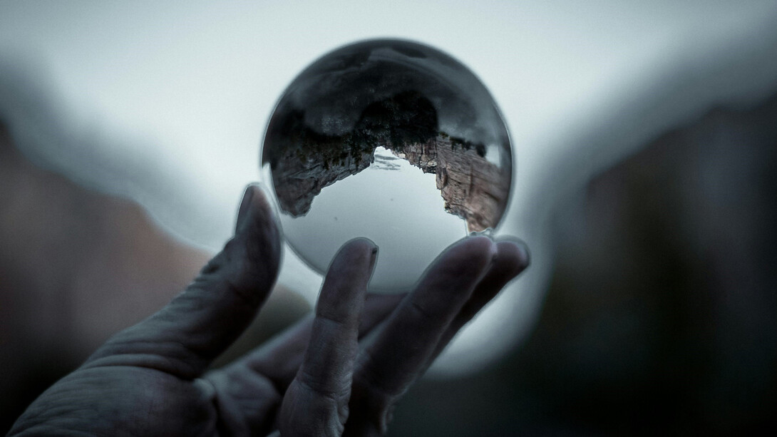 A hand cradling the world, representing care for global issues and environmental stewardship