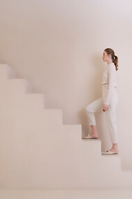 A woman climbing endless stairs, symbolizing the ongoing journey of personal growth and development