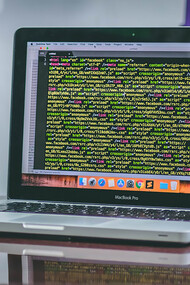 An open MacBook Pro displaying coding scripts, illustrating the integration of Web3 technologies