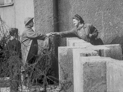Amigos se toman de la mano a pesar de encontrarse en lados opuestos del Muro de Berlín en 1961
