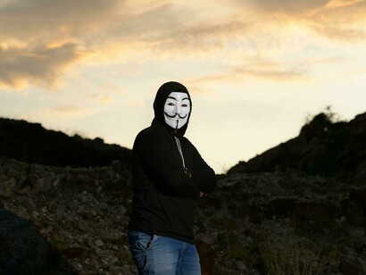 Protester in a Guy Fawkes mask, embodying defiance toward established democratic norms