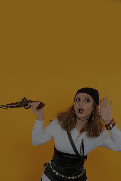 Young pirate girl holding gun and trying to hear
