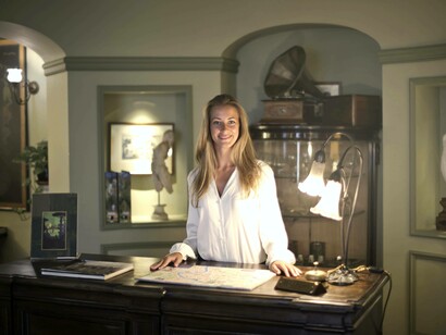 A woman at the front desk of a hotel earning wages overseas
