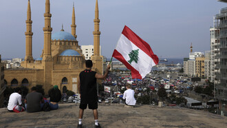 Manifestante ondeando una bandera libanesa durante una protesta en Beirut, Líbano, el 25 de octubre de 2019