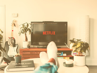 Hombre viendo Netflix en la televisión como máxima expresión de la zona de confort. Hemos perdido la capacidad de leer una hora seguida sin consultar varias veces nuestro teléfono móvil