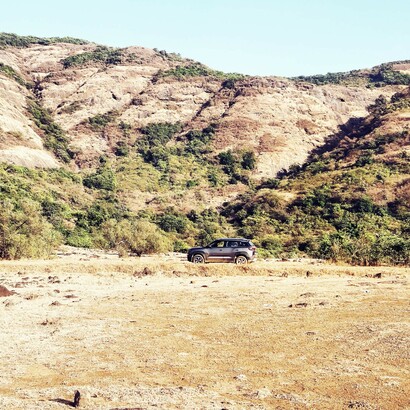 A brown Maruti Brezza explores the dirt roads of the Khandala Countryside, Lonavala, India; Lonavala is most famous for being a weekend escape for residents in and around these areas

