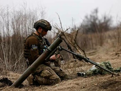 A Ukrainian soldier of the Paratroopers' of 80th brigade awaits an order to fire a mortar shell at a front-line position near Bakhmut, in the Donetsk region, Ukraine
