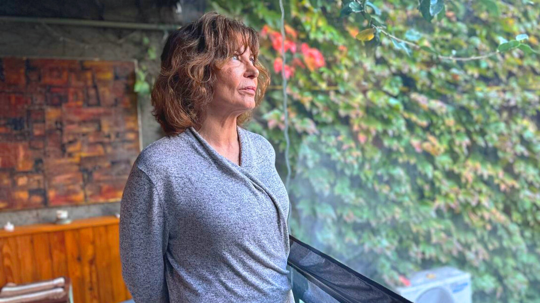 Sylvia Labayru gazes out of the window, her expression reflecting the weight of her past and the complexity of her journey