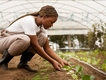 A woman tending to her urban farm, fostering sustainable agriculture and encouraging local food production